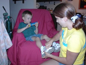 It was time to go. Carrie helped to put his shoes on.